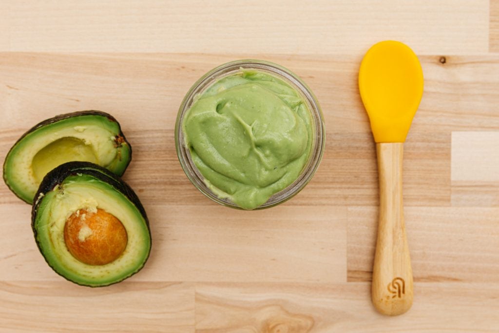 avocado baby food puree in a glass jar on the table