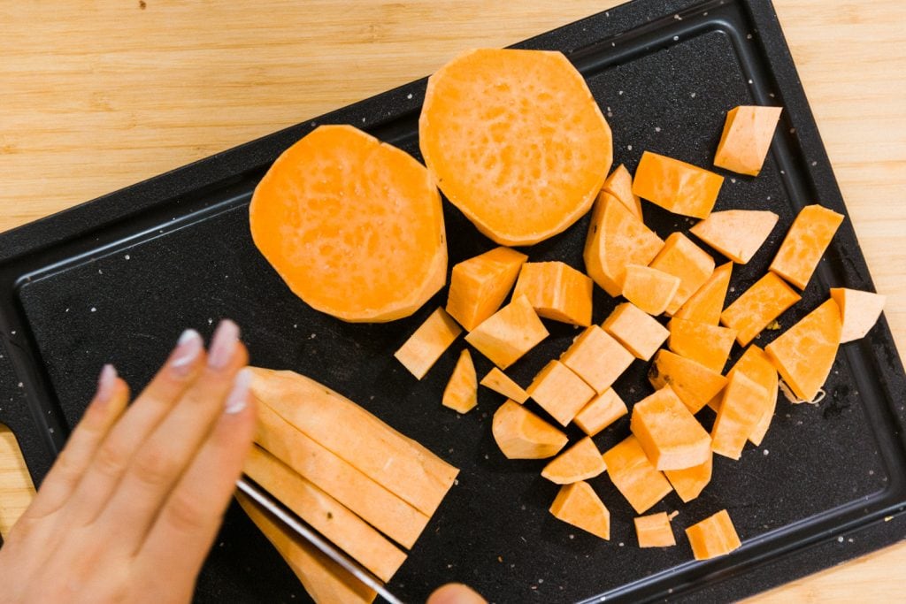 chopping the peeled sweet potatoes into 1-inch cubes