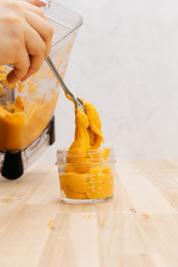 transfering sweet potato puree into a glass jar